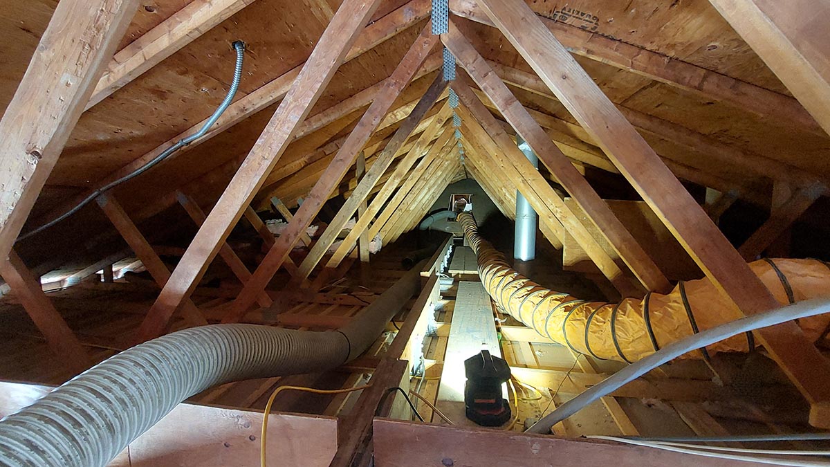 At a typical retrofit project, Sisler’s Energy Division vacuums old insulation out of an attic in prepara- tion for air sealing the attic. (Courtesy photo)